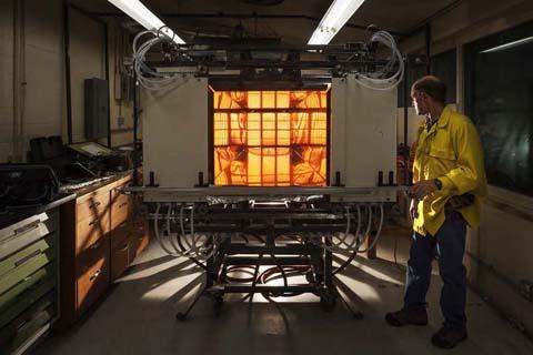 demonstrates use of the glowing radiant panel. Surrounded by reflections from elliptical mirrors, the panel allows researchers to examine the effects of radiant heat on ignition rates.